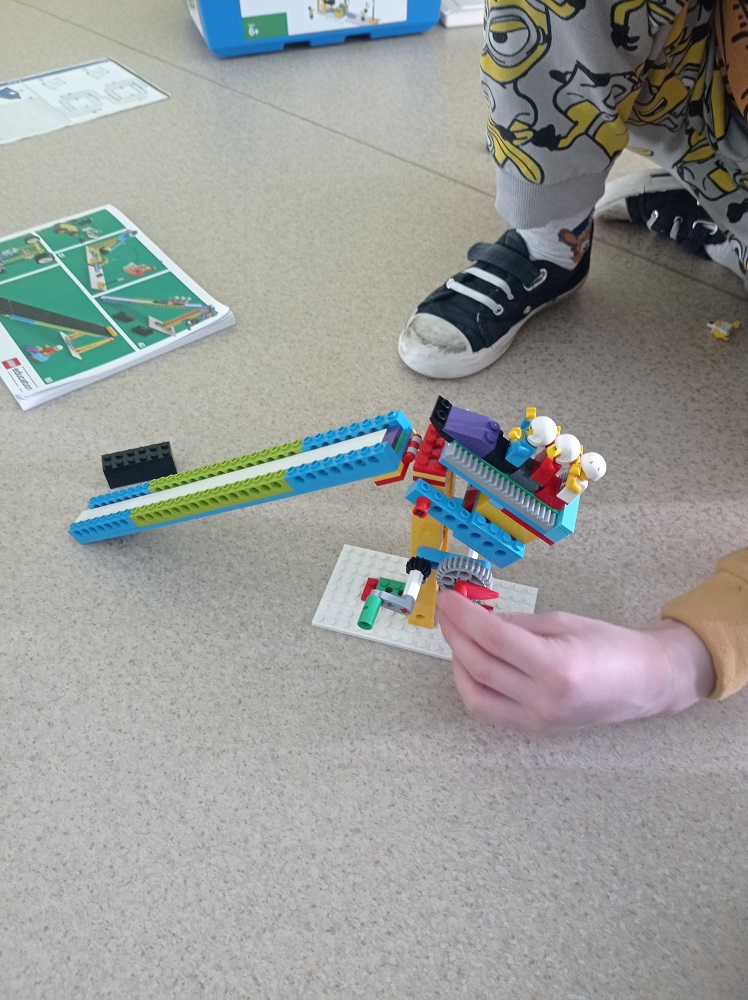 uczeń testujący działanie projektu stworzonego z klocków Lego