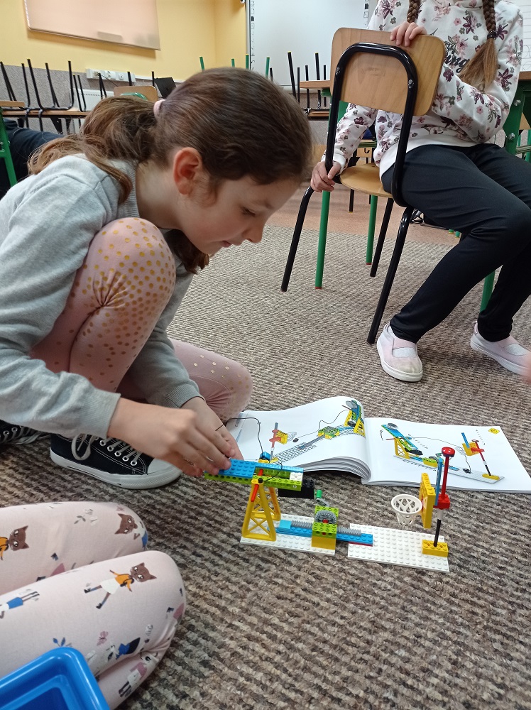 dziewczynka podczas tworzenia projektu z klocków Lego