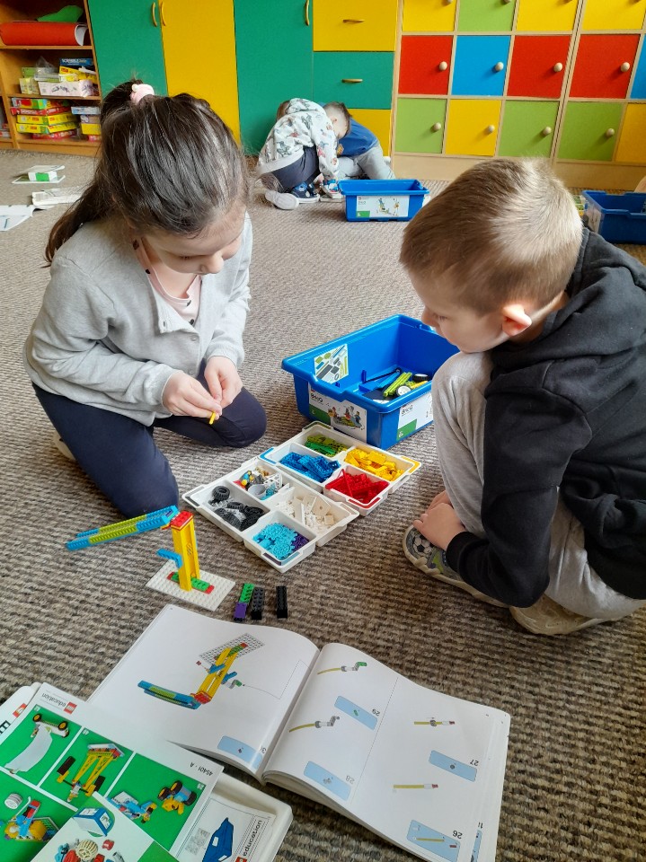 dwoje uczniów podczas tworzenia projektu z klocków LEGO