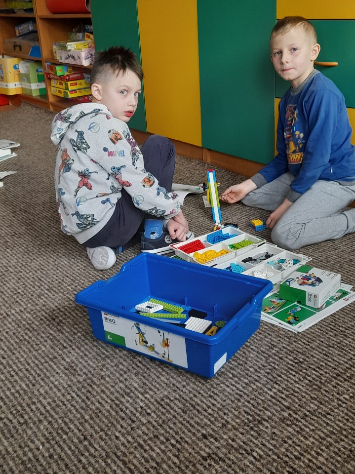 dwóch uczniów podczas tworzenia projektu z klocków LEGO