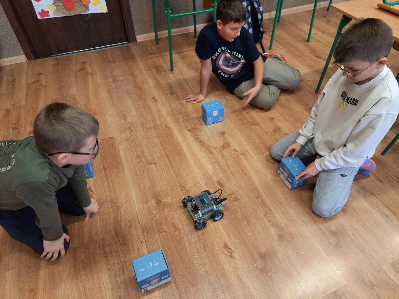 troje uczniów testujących robota z klocków vex iq