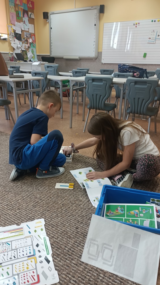 dwoje uczniów budujących projekt z klocków Lego
