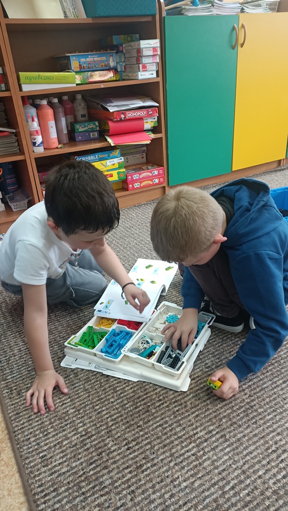 dwóch uczniów budujących projekt z klocków Lego
