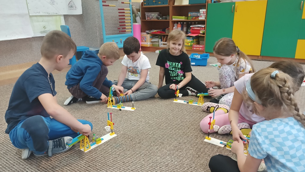 kilkoro uczniów budujących projekt z klocków Lego