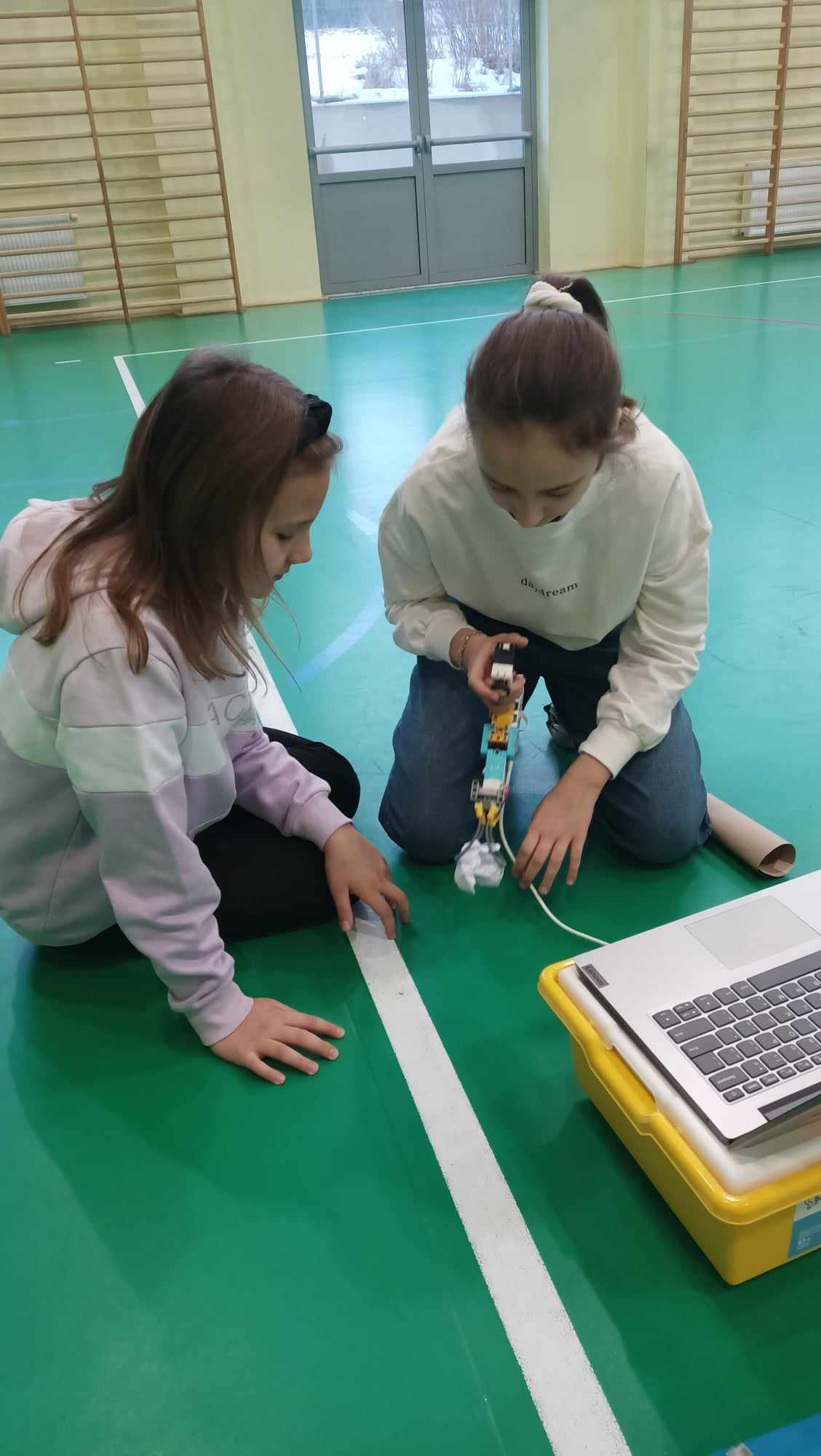 dwie uczennice testujące działanie robota zbudowanego z klocków Lego SPIKE Prime