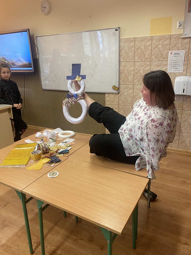 kobieta prezentujaca pracę wykonaną za pomocą nóg