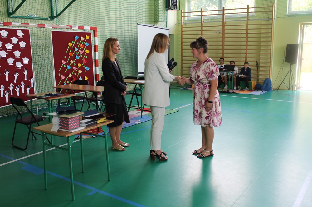 pożegnanie absolwentów szkoły - akademia dyrektor wręczająca podziękowanie rodzicowi