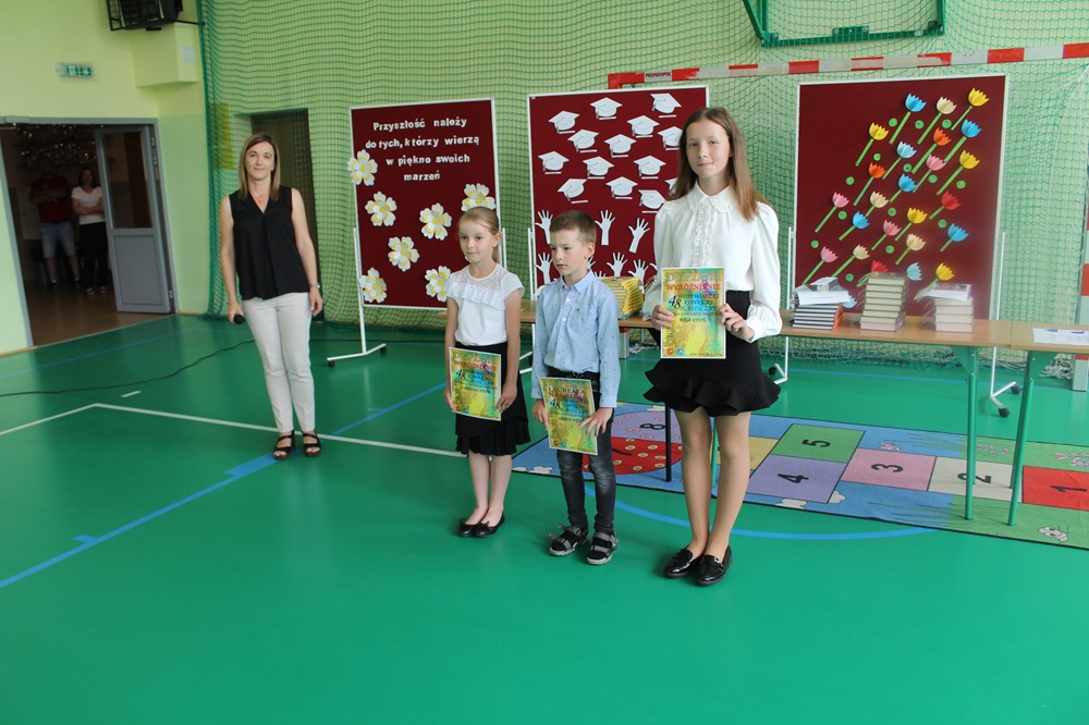 zakończenie roku szkolnego - akademia, troje uczniów nagrodzonych