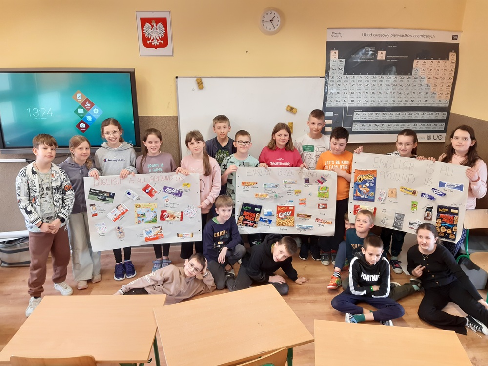 grupa uczniów prezentująca pracę - plakat