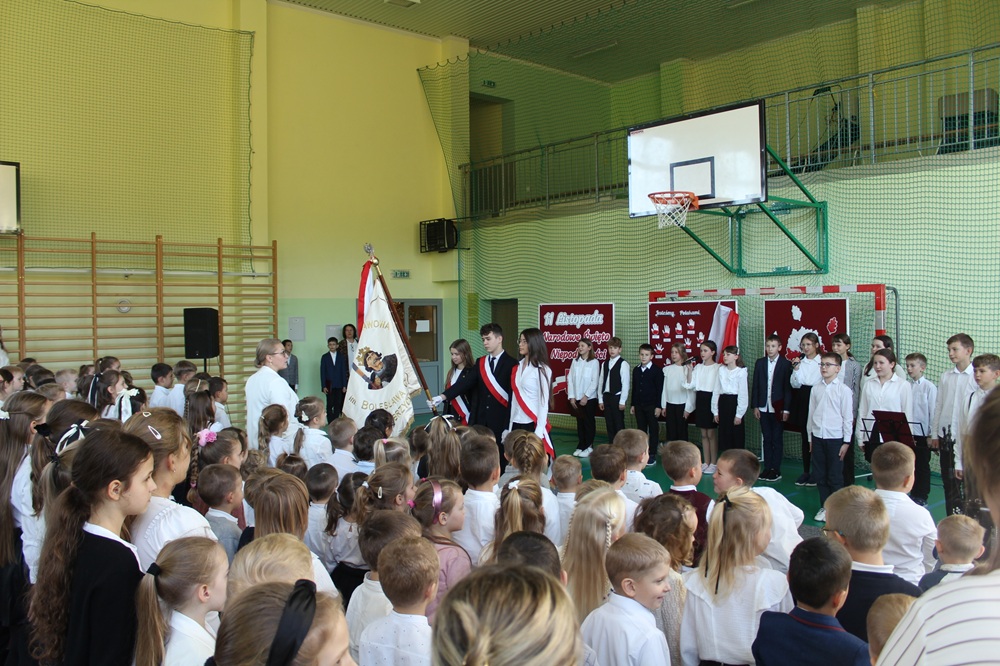 grupa uczniów wraz ze Sztandarem Szkoły podczas akademii z okazji 11 listopada - odśpiewanie Hymnu Państwowego