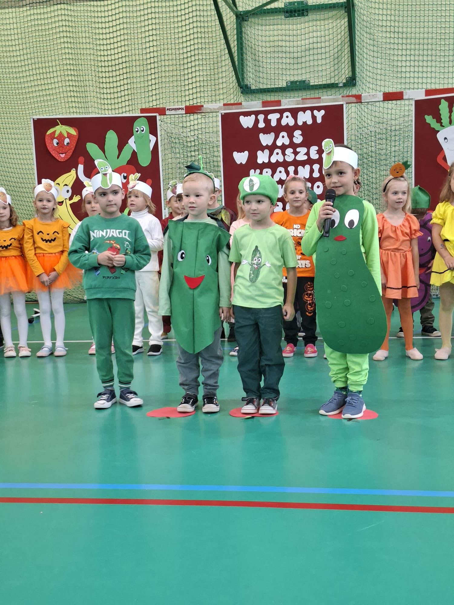 czworo dzieci w strojach warzyw podczas występu