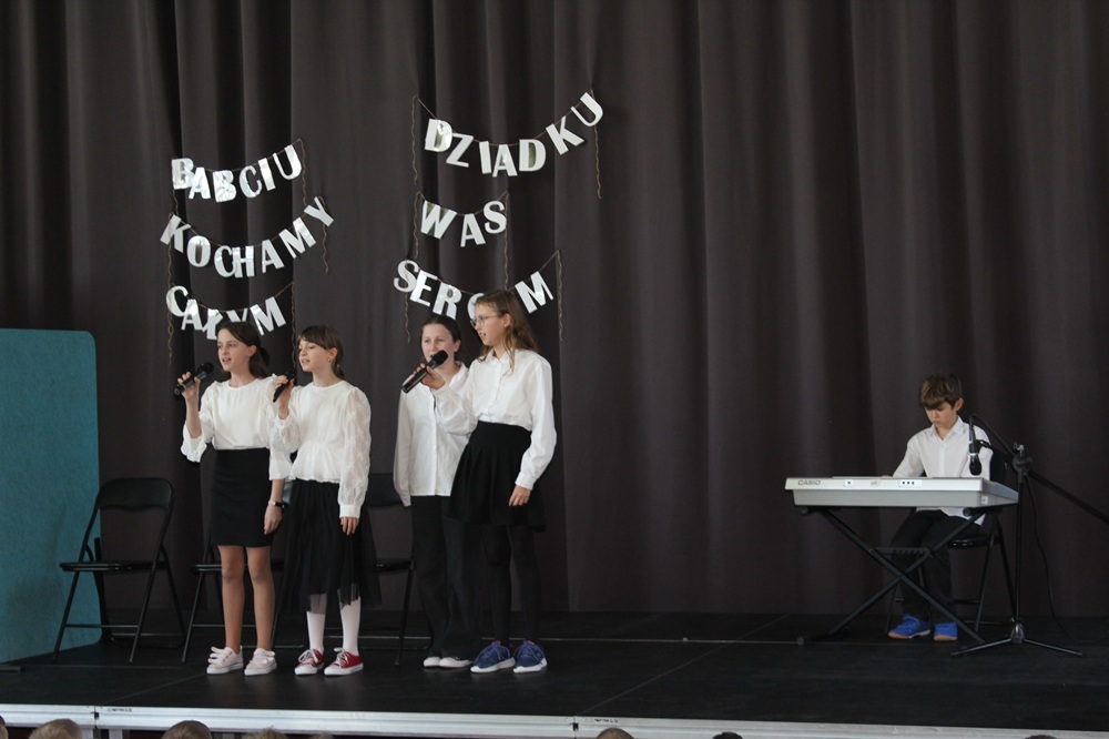 czworo dzieci na scenie podczas akademii z okazji dnia babci i dziadka