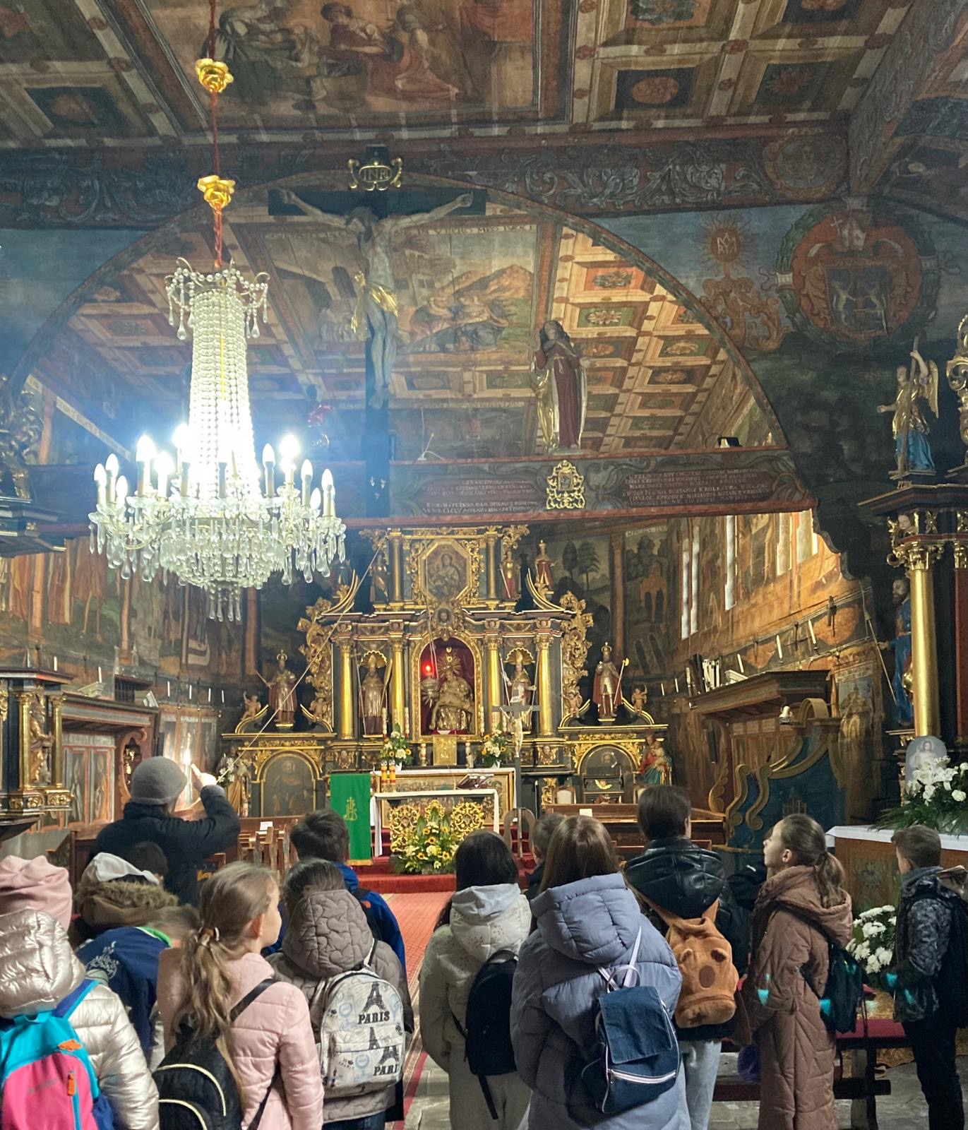kilkoro uczniów zwiedzających kościół w Orawce