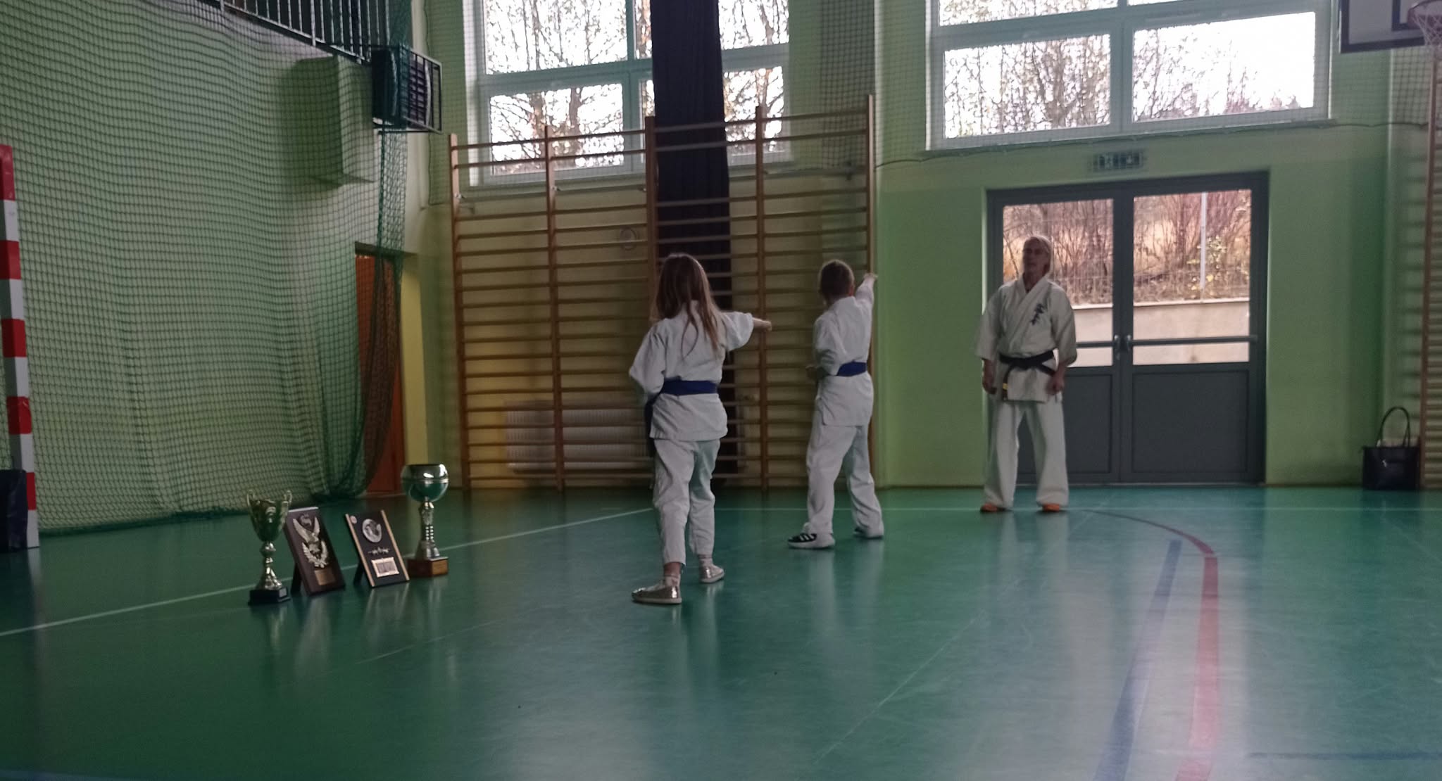 dwoje uczniów z Panią Ewą Pawlikowską prezentujących kroki karate