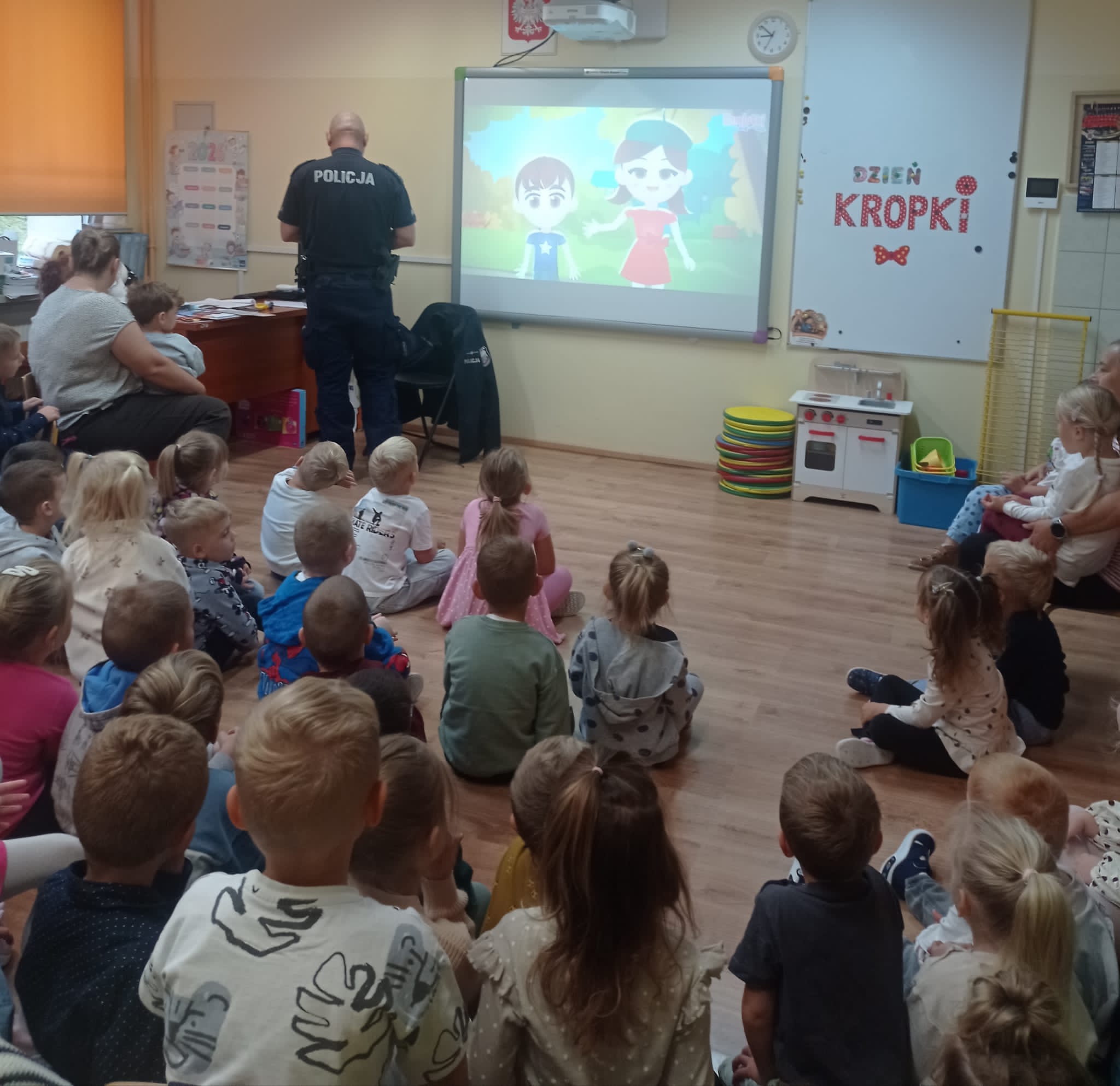 grupa dzieci przedszkolnych podczas zajęć z policjantem